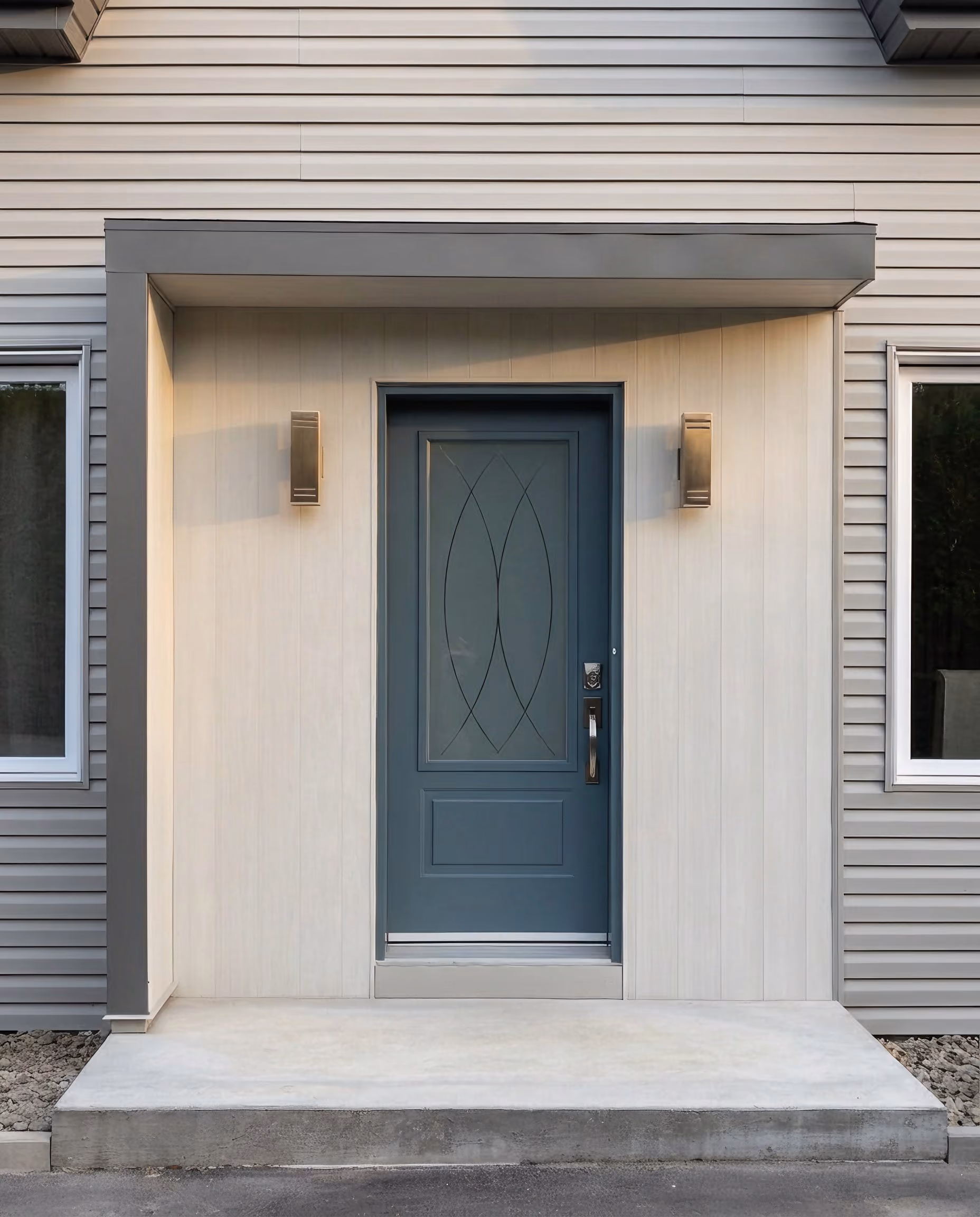 Contemporary blue-grey entry door with decorative glazing, concrete step.